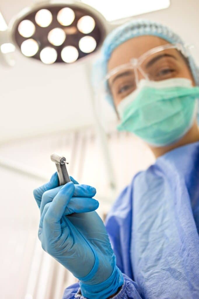 dentist with exam tools - Washington Periodontics - Dr. Christine Karapetian